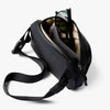 Black shoulder bag with sunglasses on a white background