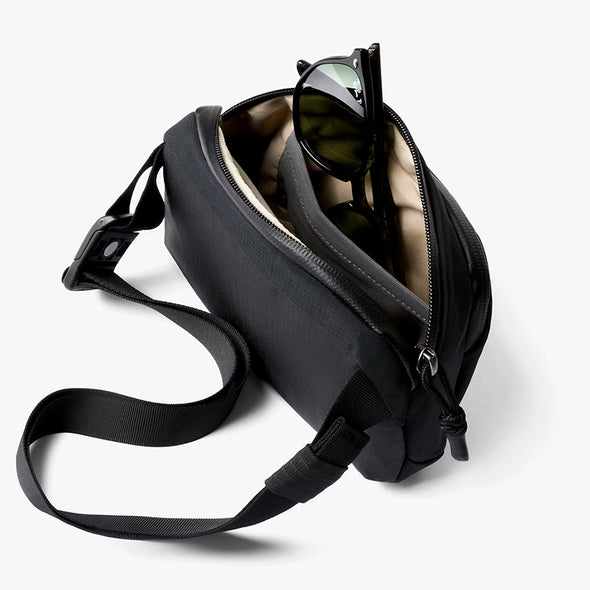Black shoulder bag with sunglasses on a white background