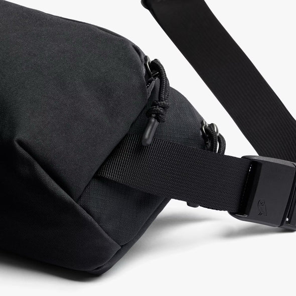Black waist bag with a strap on a white background