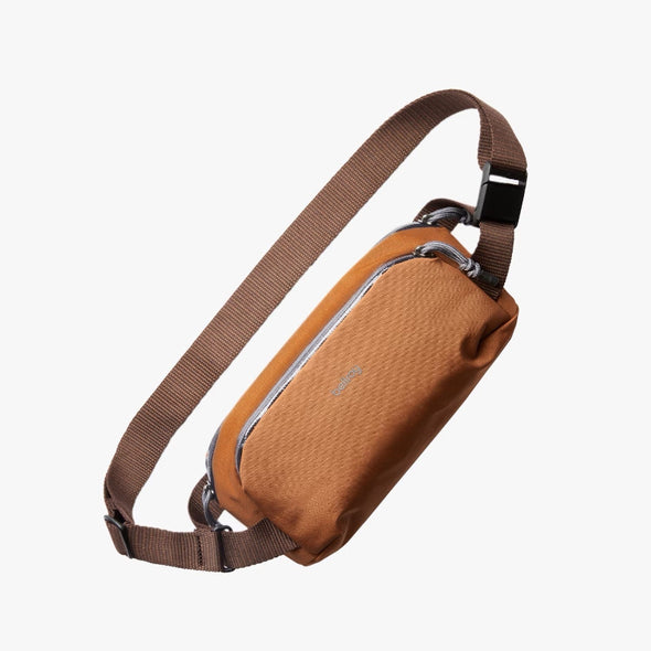 Bronze sling bag with a strap on a white background