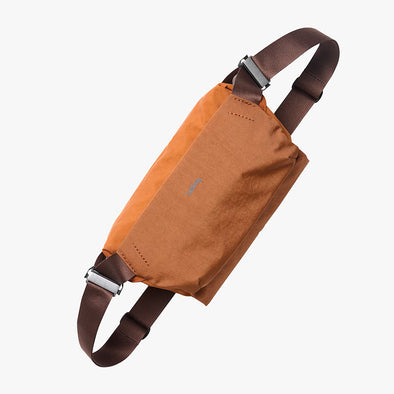 Brown crossbody bag with brown straps on a white background