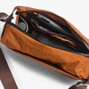 Brown leather bag with interior details on a light gray background