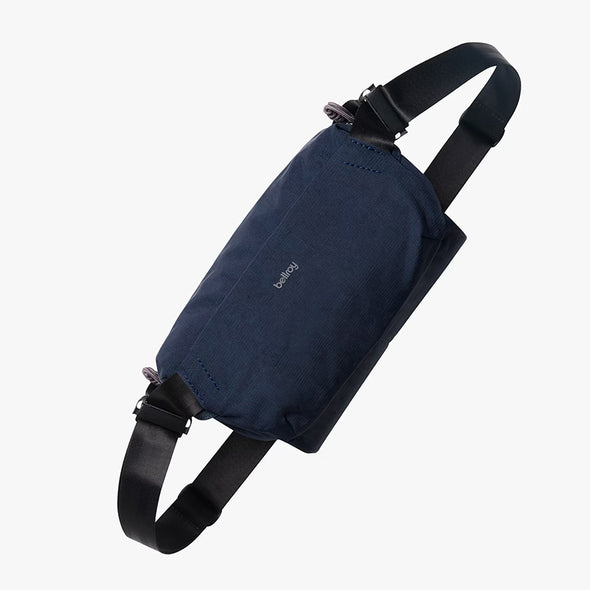 Navy blue sling bag with a strap on a white background