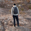 Person with a backpack walking on a rocky trail