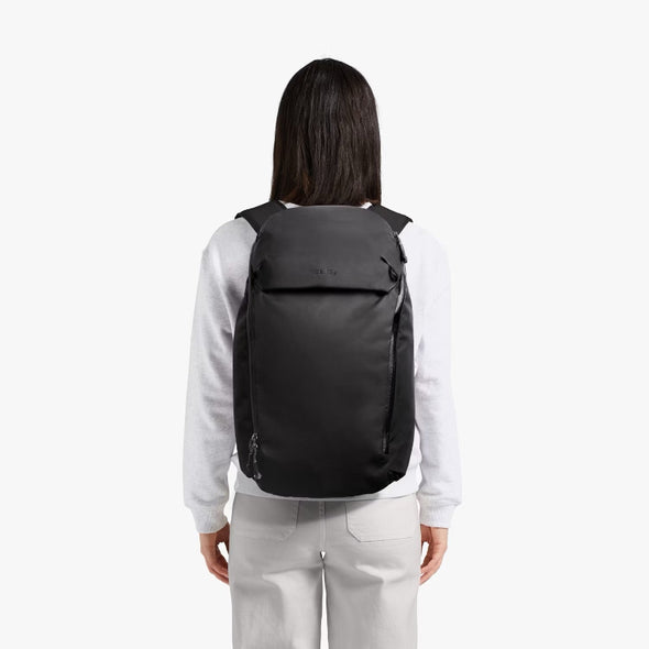 Person wearing a black backpack on a white background