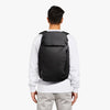 Person wearing a black backpack on a white background