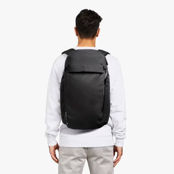 Person wearing a black backpack on a white background