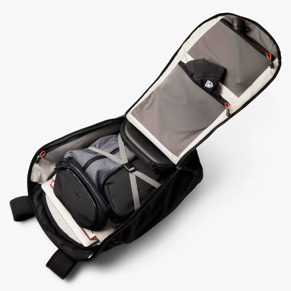 Open black travel bag with organized contents on a white background