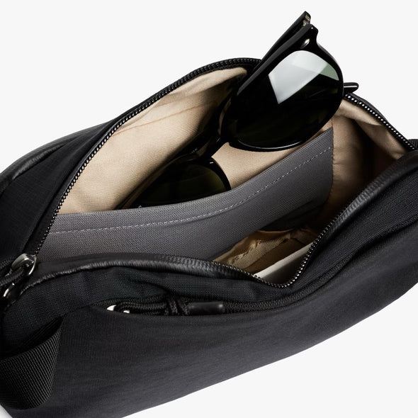 Black bag with sunglasses inside on a white background