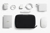 Collection of electronic accessories including a Tech Kit Compact by Bellroy, white mouse, and various cables on a white background.