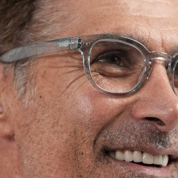 Close-up of a person wearing IZIPIZI Reading Glasses Collection #C in Frozen Blue with a focus on the glasses.