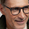 Close-up of a man wearing tortoise IZIPIZI Reading Glasses Collection #E  with a neutral background