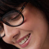 Close-up of a person wearing glasses with a blurred background