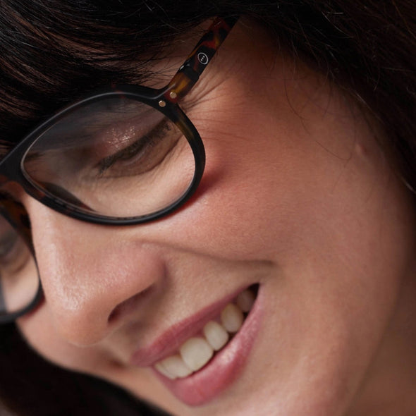 Close-up of a person wearing glasses with a blurred background
