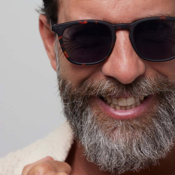 Man wearing sunglasses with a neutral background