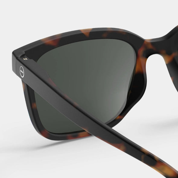 Sunglasses with tortoiseshell frame and dark lenses on a white background