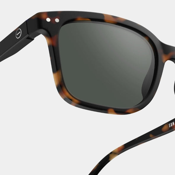 Sunglasses with tortoiseshell frame and dark lenses on a white background