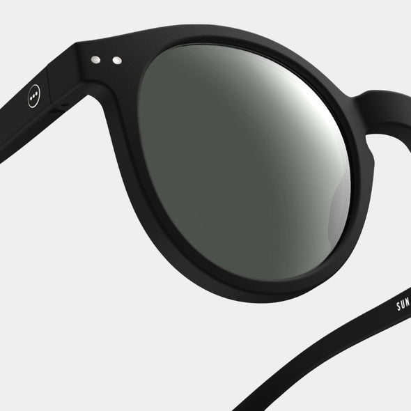 Black sunglasses with reflective lenses on a light gray background