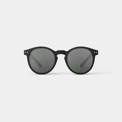 Black sunglasses with dark lenses on a light gray background