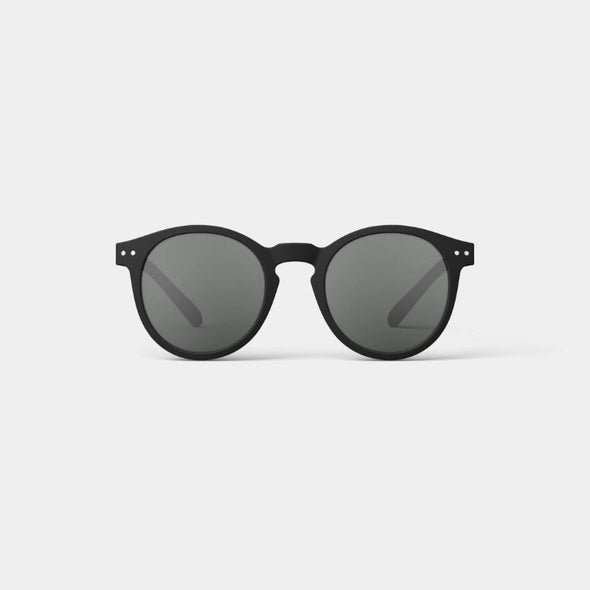 Black sunglasses with dark lenses on a light gray background