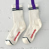 White socks with purple tape and 'Le bon Shoppe' branding on a gray background