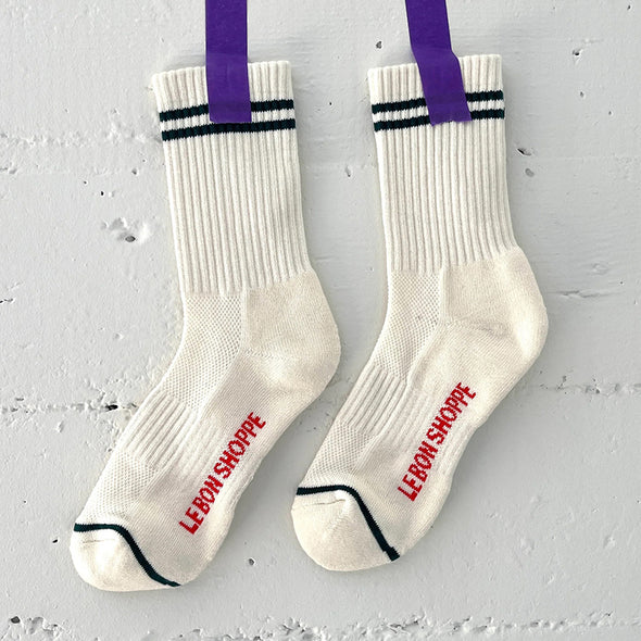 White socks with purple tape and 'Le bon Shoppe' branding on a gray background