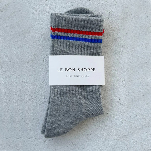 Gray socks with red and blue stripes on a gray background, featuring 'Le Bon Shoppe' label.