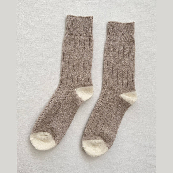 Pair of fawn brown socks with white toes on a light grey background