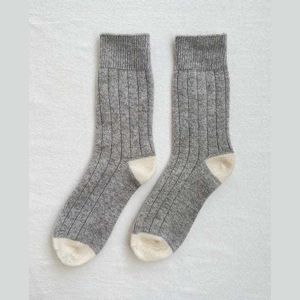 Pair of grey socks with white toes on a light grey background
