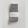 Pair of grey cashmere socks with 'Le Bon Shoppe' label on a light gray background