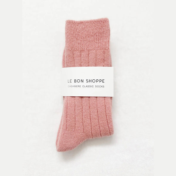 Rose Pink cashmere socks with a white label on a light grey background