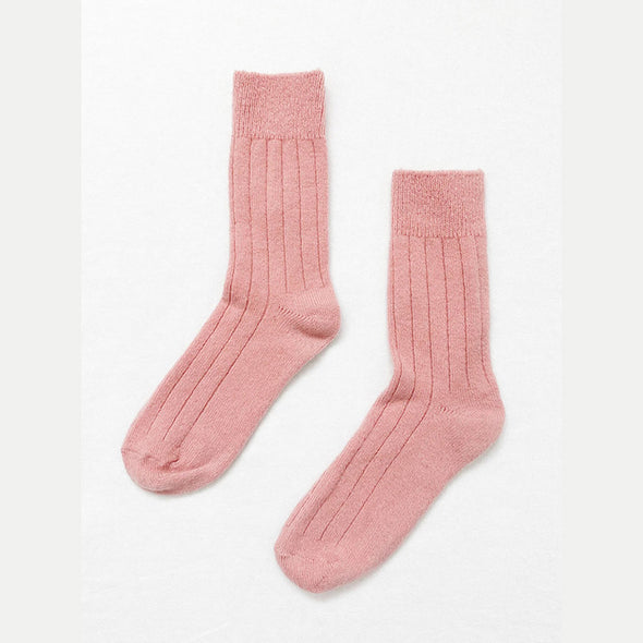 Pair of rose pink cashmere socks on a white background
