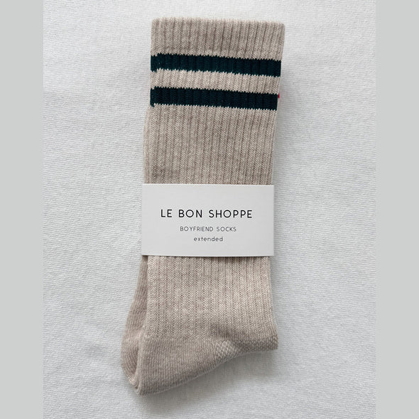 Beige sock with black stripes and 'Le Bon Shoppe' label on a light gray background