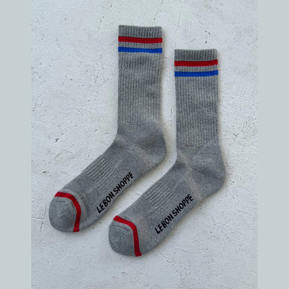 Gray socks with red and blue stripes on a light gray background