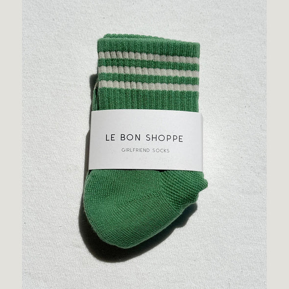 Green socks with white stripes on a light gray background, featuring 'Le Bon Shoppe' label.