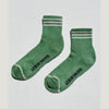 Green socks with striped cuffs and toes on a light gray background