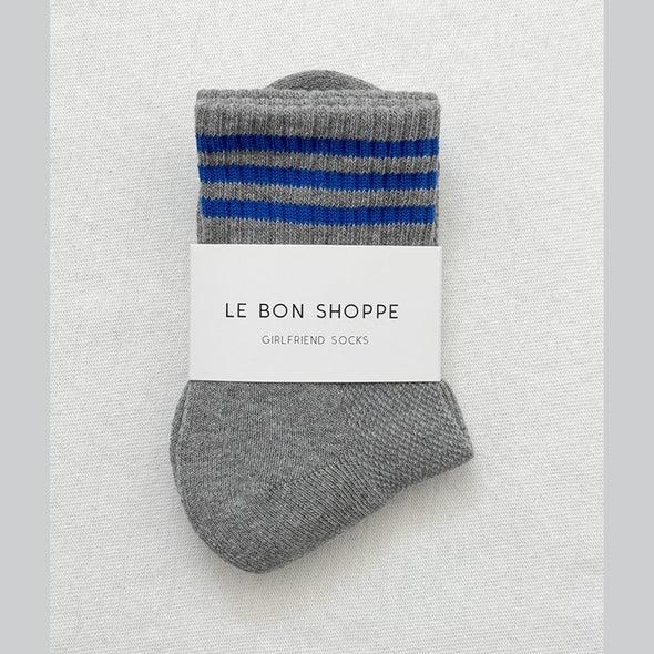 Grey socks with blue stripes on a white background, featuring 'Le Bon Shoppe' branding.