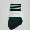 Green sock with white stripes and 'Le Bon Shoppe' label on a light gray background