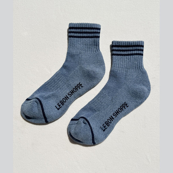 Pair of blue socks with black text on a light gray background