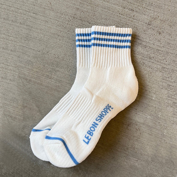 White socks with blue stripes and text on a gray surface