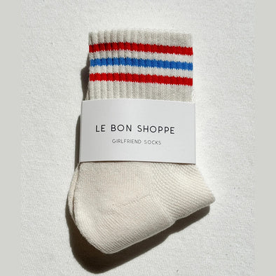 Pair of socks with red and blue stripes on a white background, featuring 'Le Bon Shoppe' label.