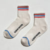 Pair of socks with striped cuffs and blue toes on a light gray background