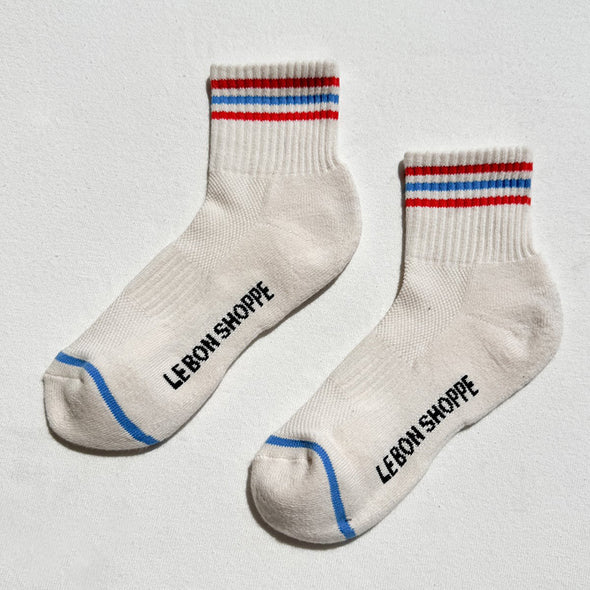 Pair of socks with striped cuffs and blue toes on a light gray background