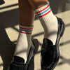 feet wearing black shoes and Le Bon Shoppe Girlfriend Socks in white with 3 red and blue stripes
