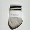 Oatmeal sock with blue stripes and 'Le Bon Shoppe' label on a light gray background