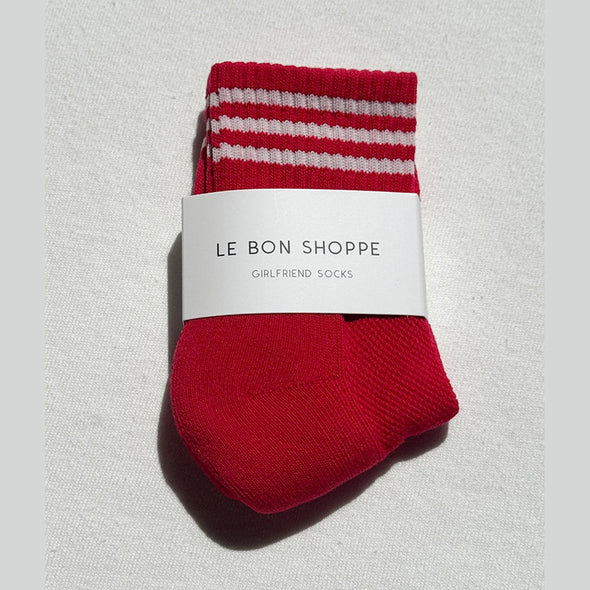 Red sock with white stripes on a light gray background, featuring 'Le Bon Shoppe' label.
