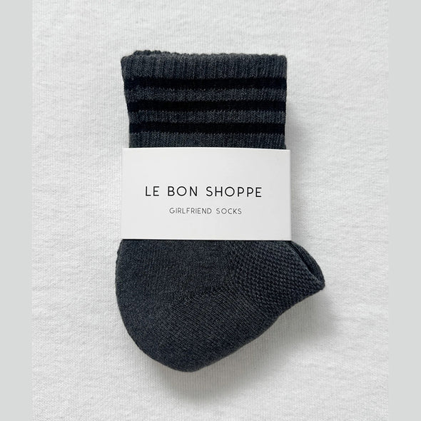 Pair of dark gray socks with a white label on a light gray background