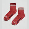 Terracotta socks with white stripes and 'Le Bon Shoppe' branding on a light gray background