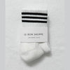 White sock with black stripes on a light gray background, featuring 'Le Bon Shoppe' branding.