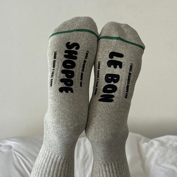 Gray socks with black text on a white surface